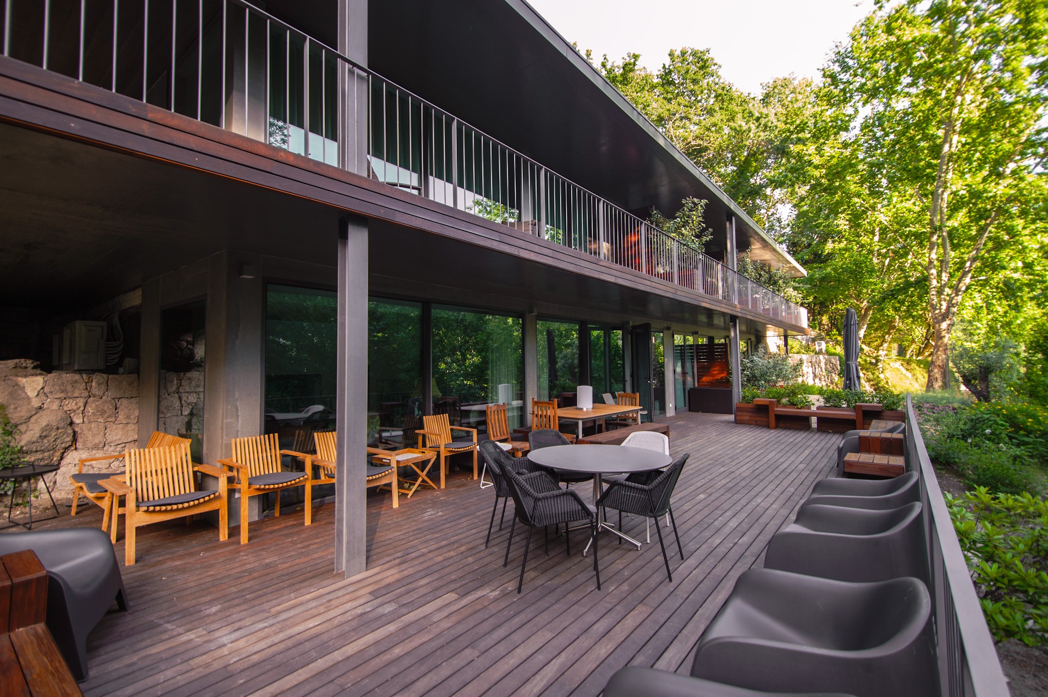 Large wooden terrace with seating and tables at Runas Carqueijais in Gerês