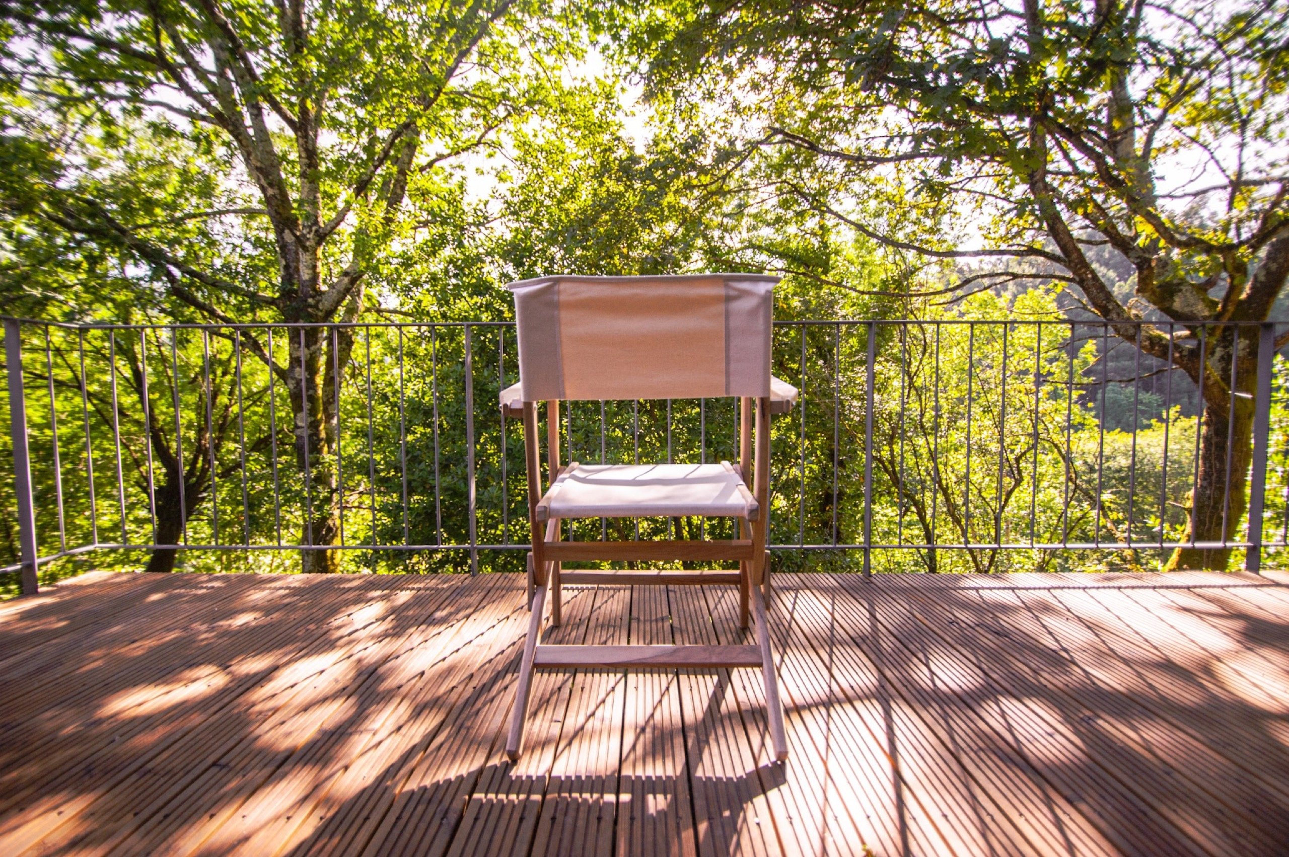 Wooden chair on a terrace at Runas Carqueijais in Gerês surrounded by trees