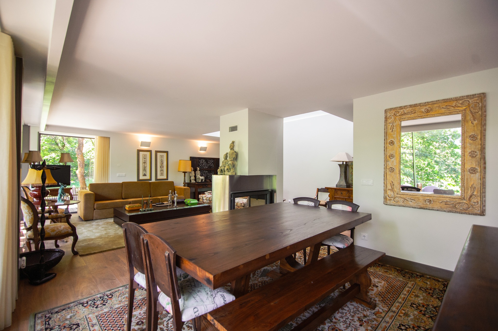 Dining room with long wooden table, chairs, and fireplace in an open living space at Runas 108 in Porto